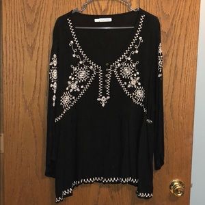 Black peplum style top with cream embroidery.